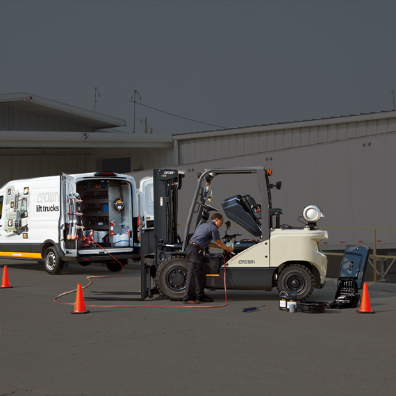 Service tech performing maintenance on C-G Series with body panels removed